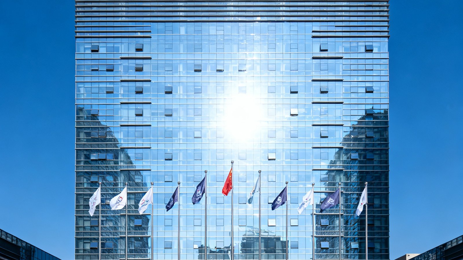 必发6690集团广州总部办公大楼外景，现代化玻璃幕墙建筑在阳光下熠熠生辉，楼前旗帜飘扬，彰显企业实力与专业形象。